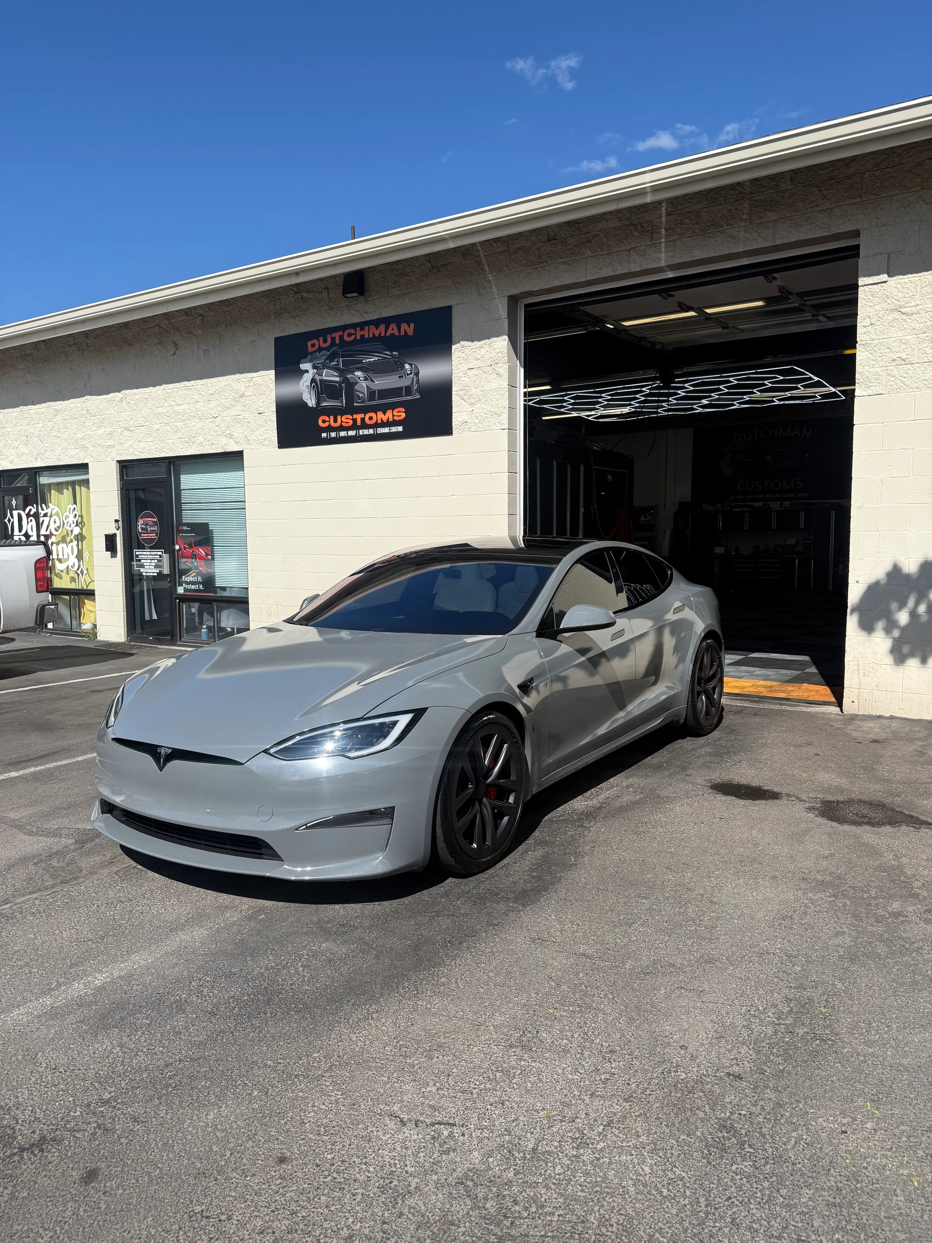 Grey Tesla Model S Plaid outside the shop